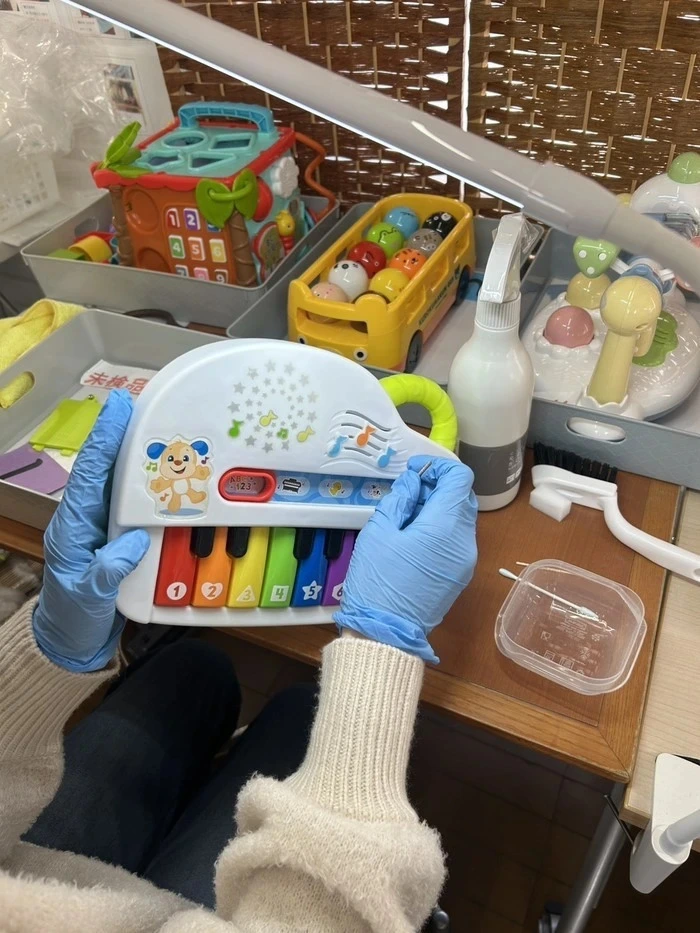 おもちゃ清掃の様子
プラスチック製の知育玩具をアルコールを含ませた綿棒で掃除している。